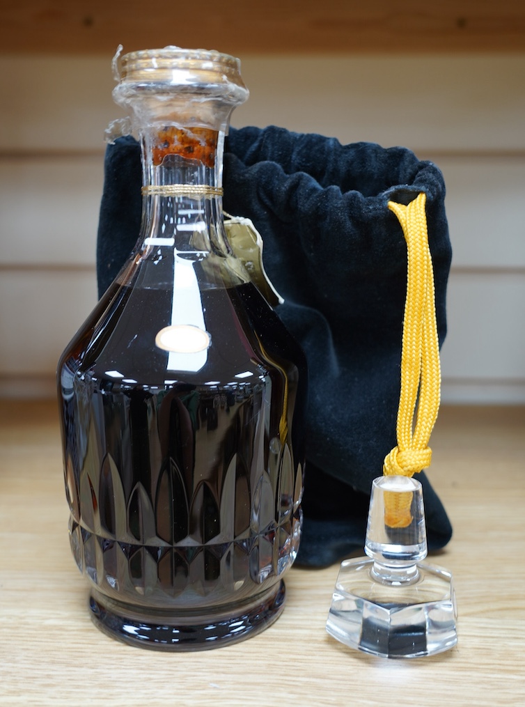 A bottle of Hennessy XO Cognac in a Baccarat crystal decanter, with separate glass stopper, contained with a drawstring bag. Condition - good